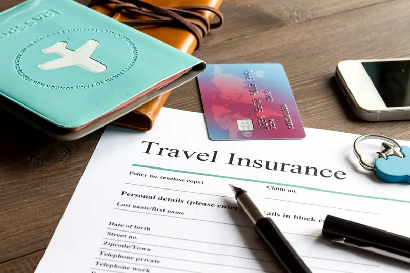 Unterlagen einer Reiseversicherung mit Reisepass und Kreditkarte