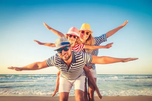 Familie mit Kindern jubelt am Strand