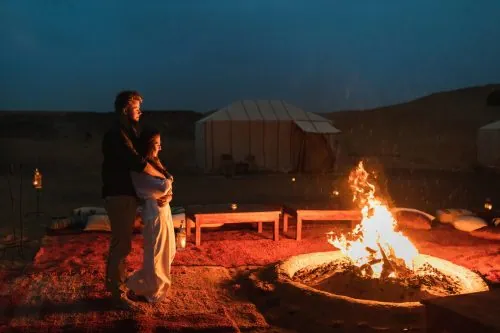 Lagerfeuer vor den Zelten eines Wüstencamps in der Sahara