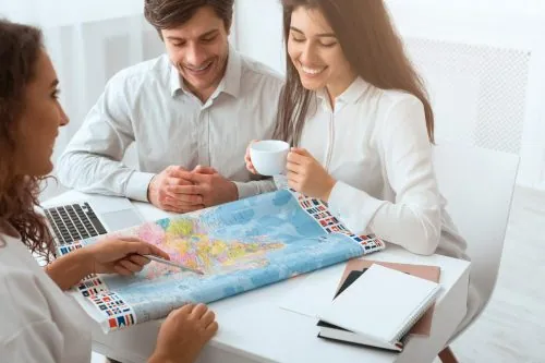 Reiseberatung mit Weltkarte im Reisebüro