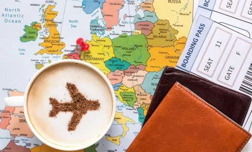 Reiseunterlagen und Kaffeetasse auf dem Schreibtisch