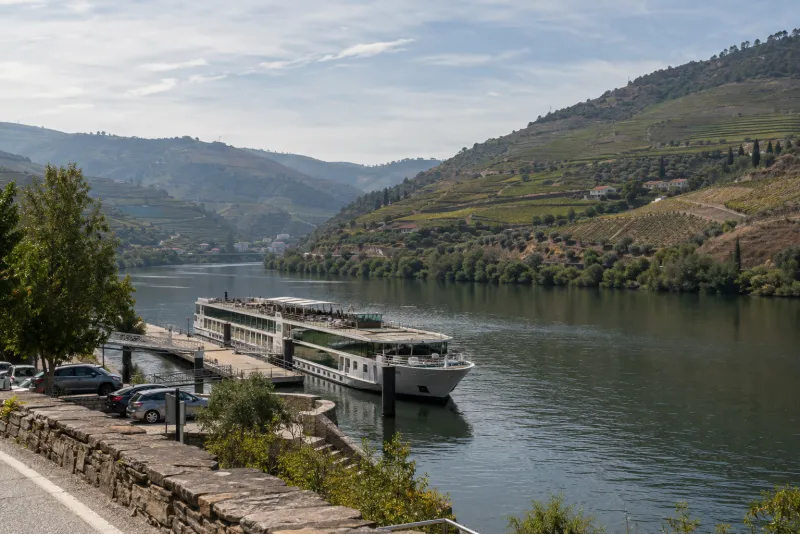 Flusskreuzfahrtschiff auf dem Douro zwischen Weinterrassen